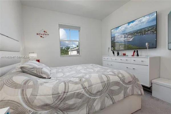 a bedroom with a bed and flat screen tv