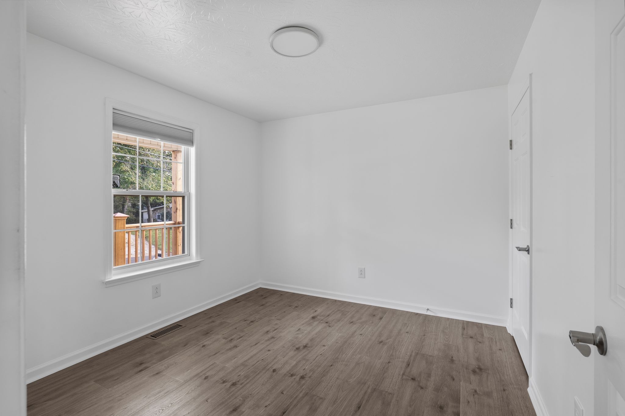 104 East Merchant Street Mount Pleasant, TN 38474 - Photo 11 of 30 an empty room with wooden floor and windows