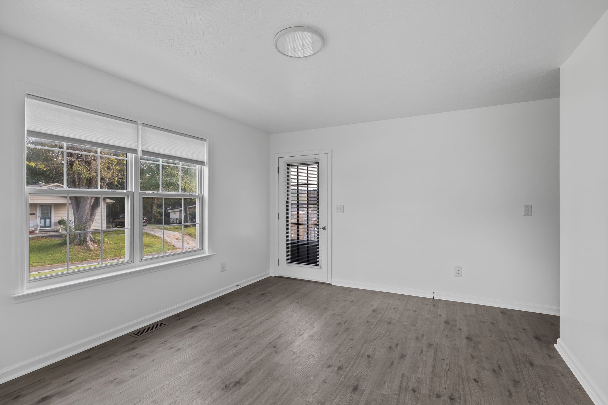 104 East Merchant Street Mount Pleasant, TN 38474 - Photo 10 of 30 an empty room with wooden floor and windows