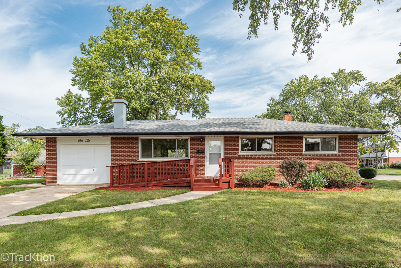 a front view of house with yard and trees in the background