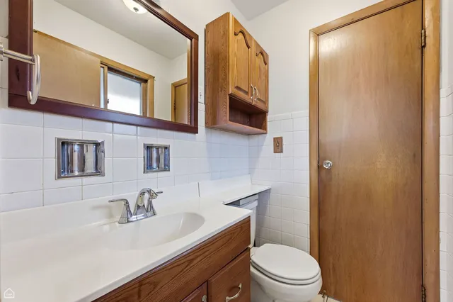a bathroom with a sink a toilet a mirror and shower