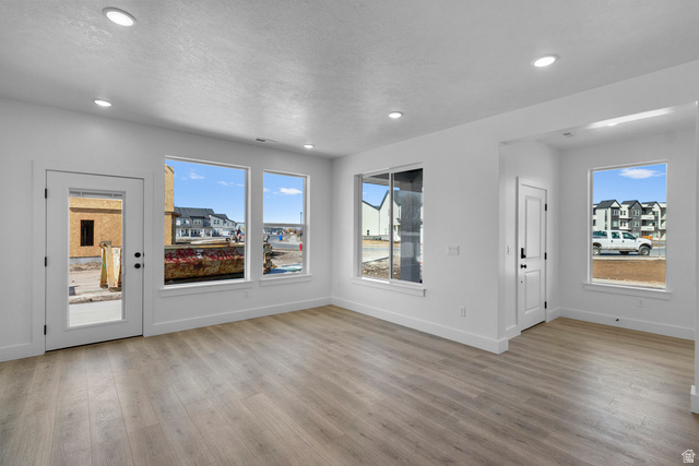 248 West 2920th Street South Logan, UT 84321 - Photo 8 of 47 Recessed lighting, wood-finish flooring, white trim, multiple windows, and a glass-paneled exterior door