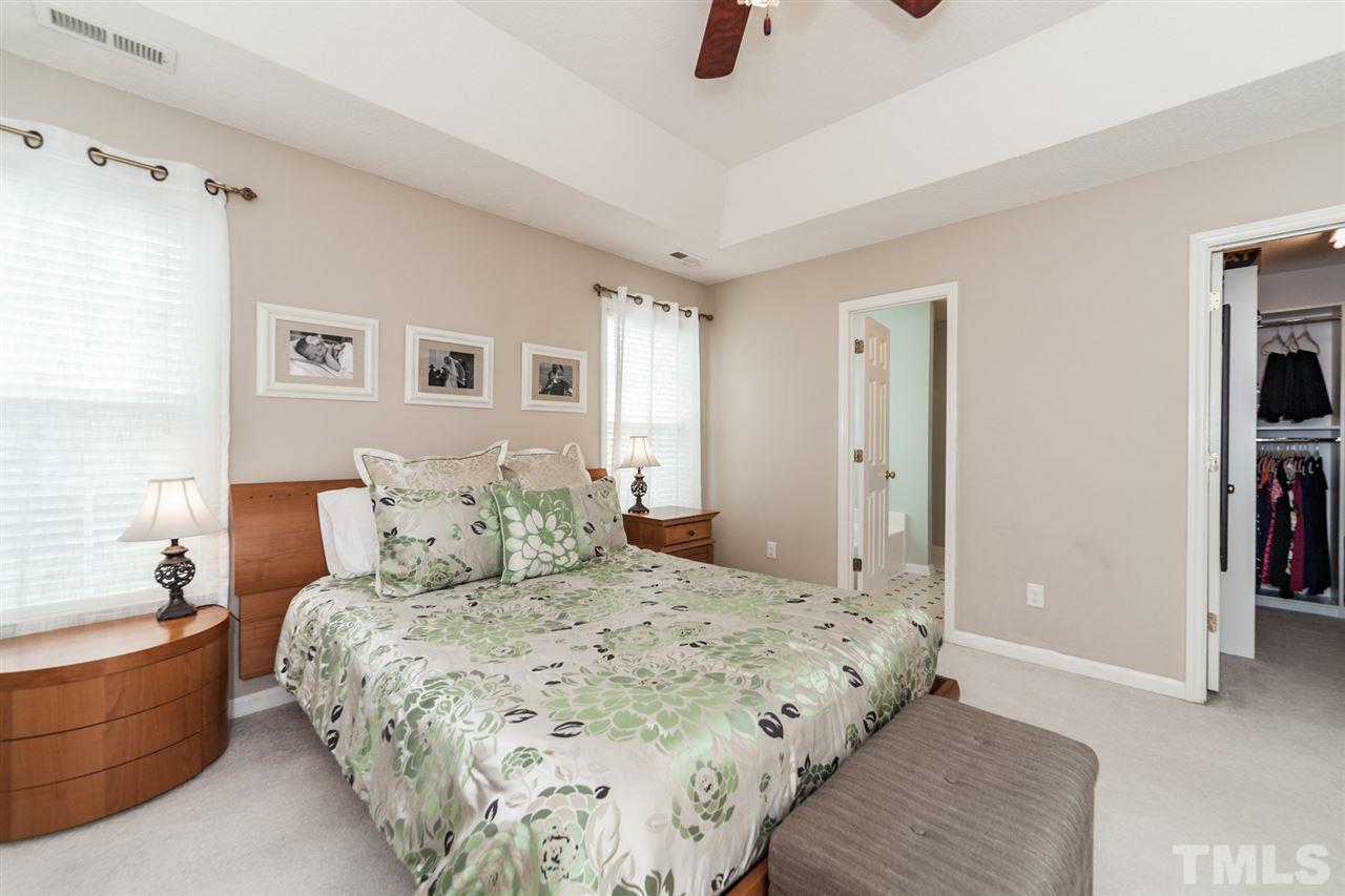 9300 Shallcross Way Raleigh, NC 27617 - Photo 12 of 25 a bedroom with a large bed and a chandelier