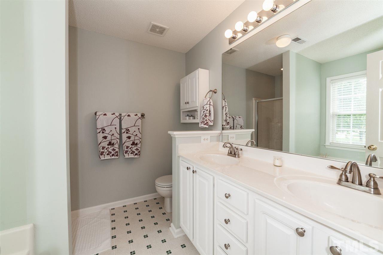9300 Shallcross Way Raleigh, NC 27617 - Photo 13 of 25 a bathroom with a sink a vanity and a mirror