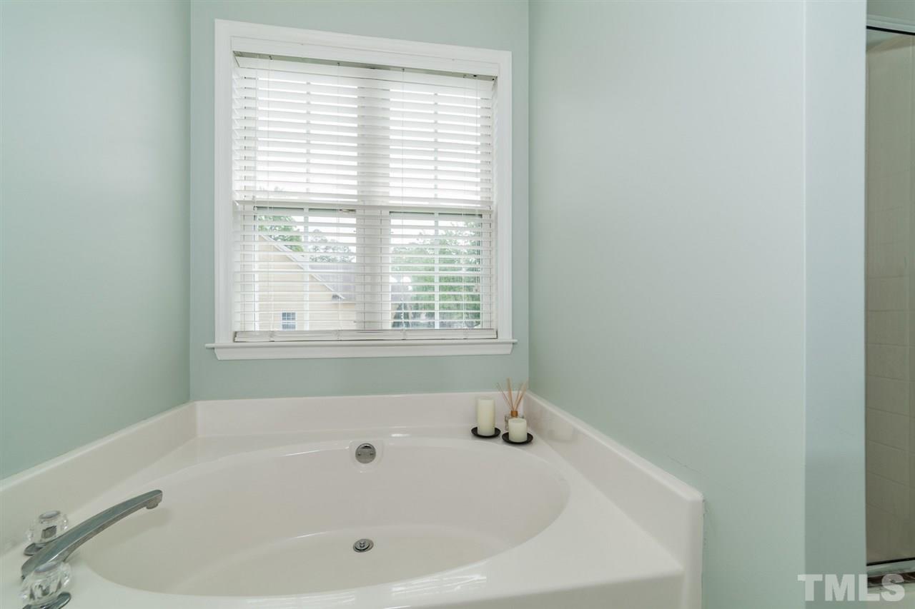9300 Shallcross Way Raleigh, NC 27617 - Photo 14 of 25 a white bath tub sitting in a bathroom next to a window