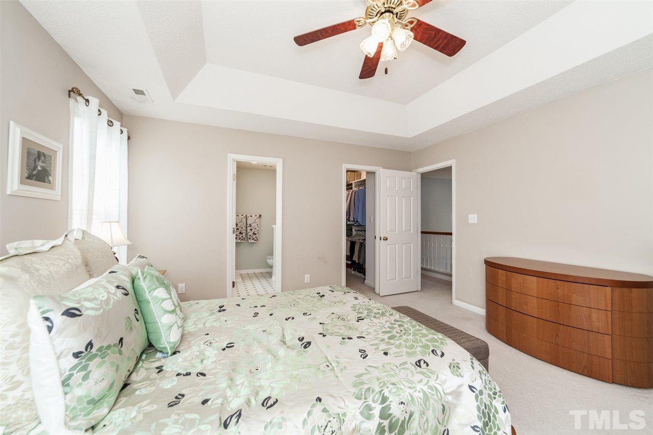 9300 Shallcross Way Raleigh, NC 27617 - Photo 15 of 25 a bedroom with a bed and a chandelier