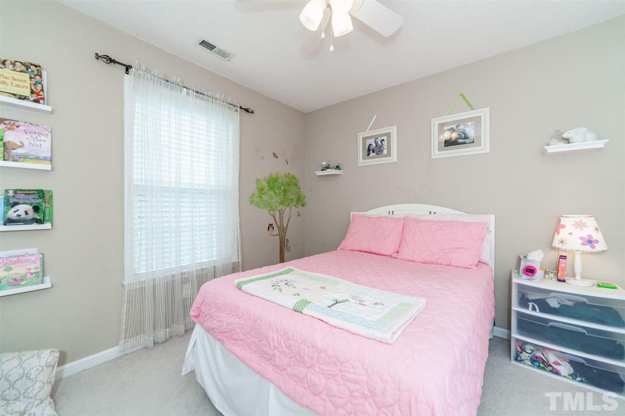 9300 Shallcross Way Raleigh, NC 27617 - Photo 16 of 25 a bedroom with a bed and a chandelier
