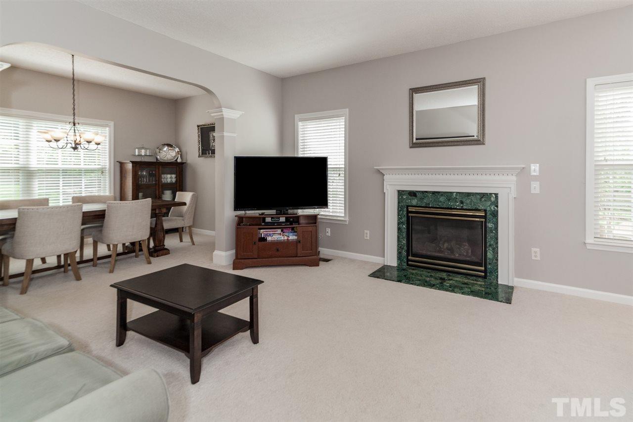 9300 Shallcross Way Raleigh, NC 27617 - Photo 4 of 25 a living room with furniture a fireplace and a flat screen tv