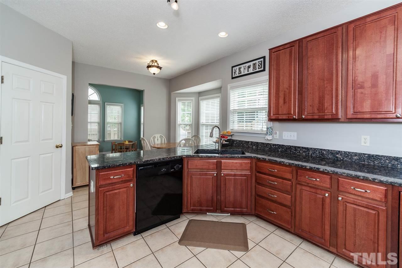 9300 Shallcross Way Raleigh, NC 27617 - Photo 7 of 25 a large kitchen with wooden cabinets