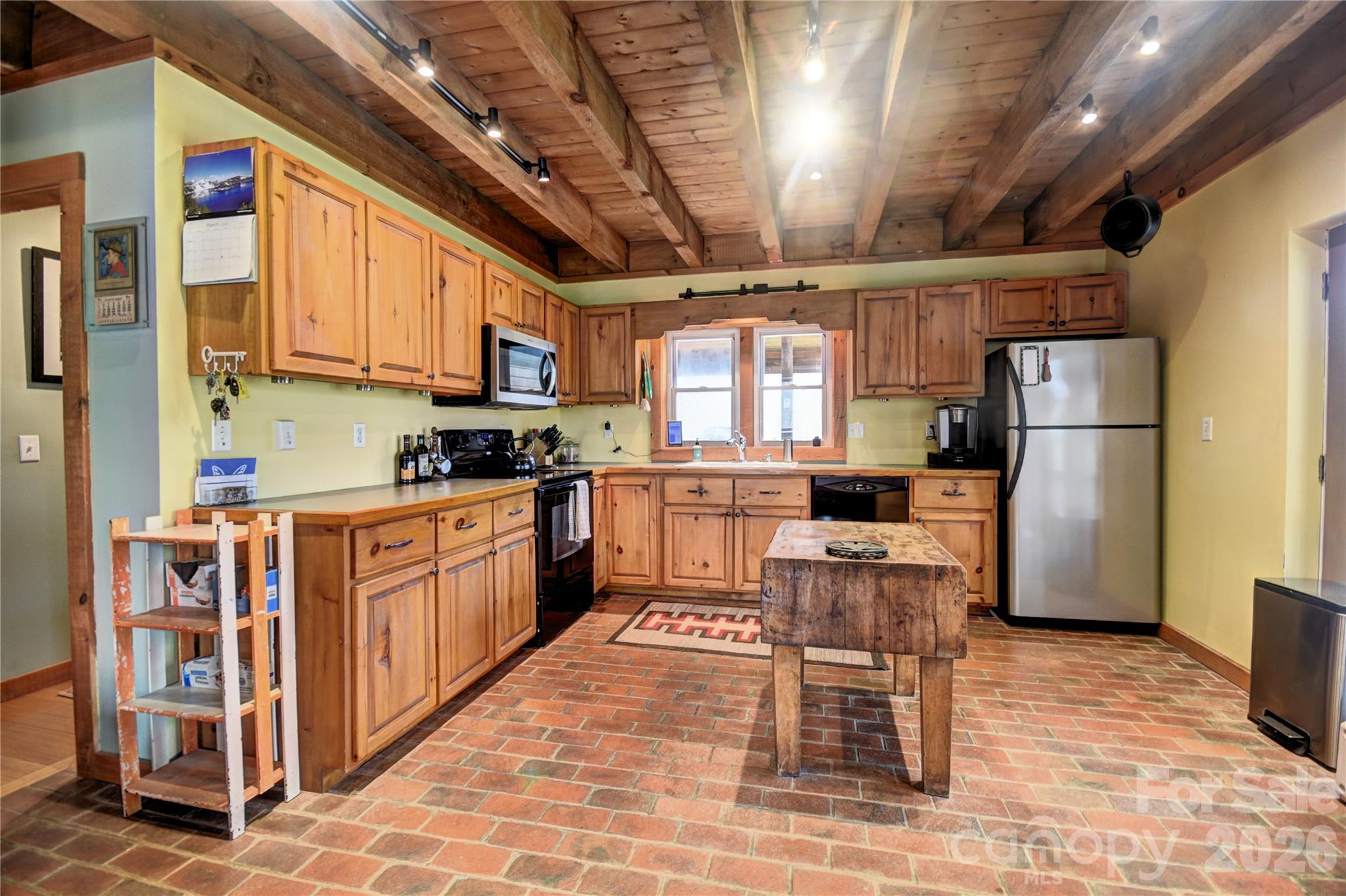 85 Homish Garden Waynesville, NC 28785 - Photo 13 of 32 a kitchen with stainless steel appliances kitchen island granite countertop a refrigerator a stove a sink a dining table and chairs with wooden floor