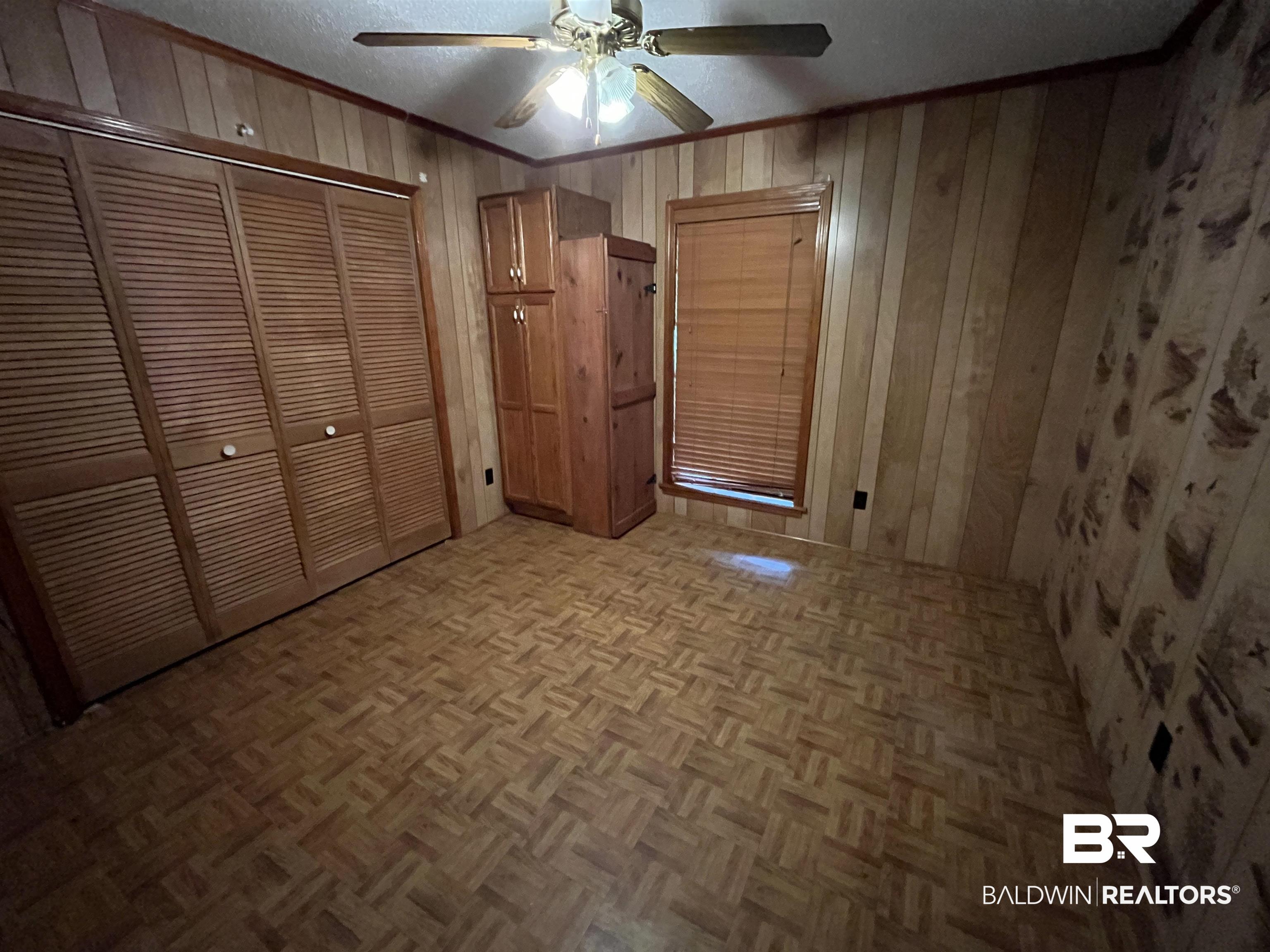 1905 Rockaway Creek Road Atmore, AL 36502 - Photo 21 of 23 Room featuring wood-finish flooring, paneled walls, and a window with blinds