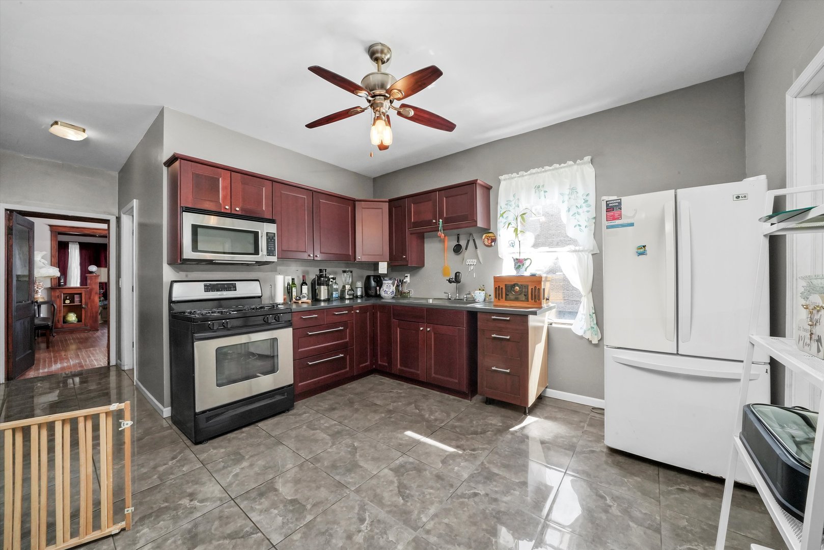 3009 West 40th Place Chicago, IL 60632 - Photo 16 of 33 a kitchen with stainless steel appliances granite countertop a refrigerator a stove a sink a dining table and chairs with wooden floor
