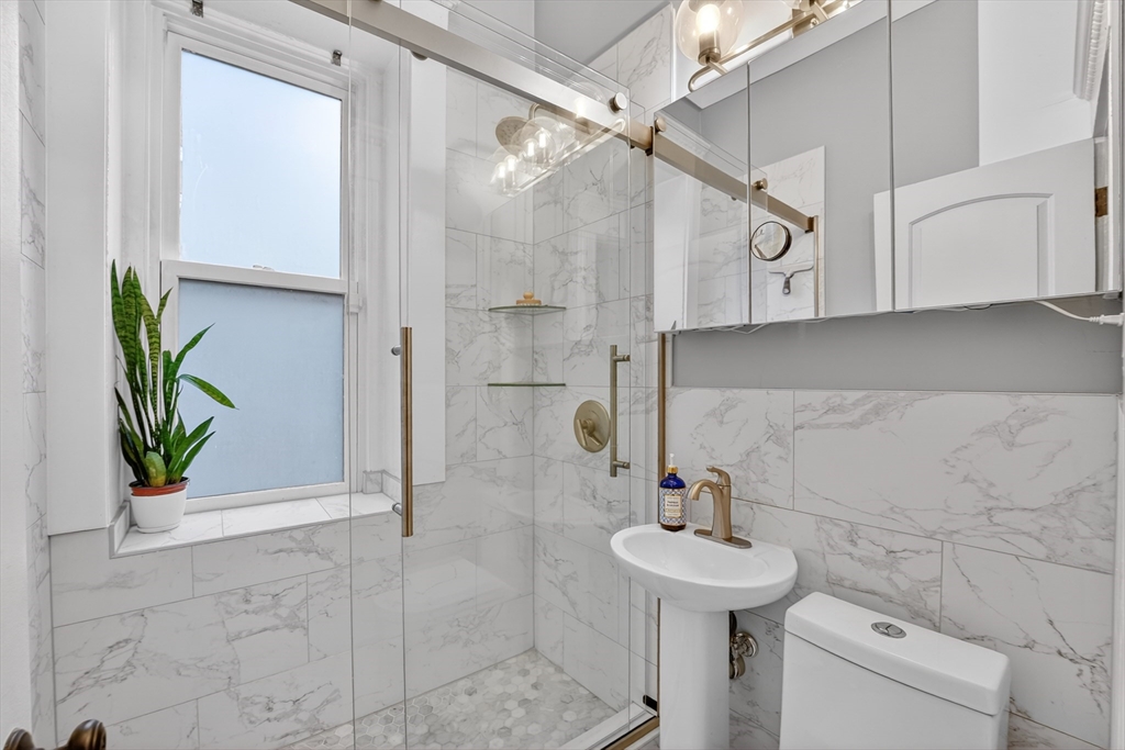 8 Garrison Street, Unit 111 Boston, MA 02116 - Photo 11 of 15 a bathroom with a sink a toilet and shower
