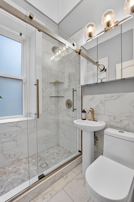 8 Garrison Street, Unit 111 Boston, MA 02116 - Photo 13 of 15 a bathroom with a sink a toilet and shower