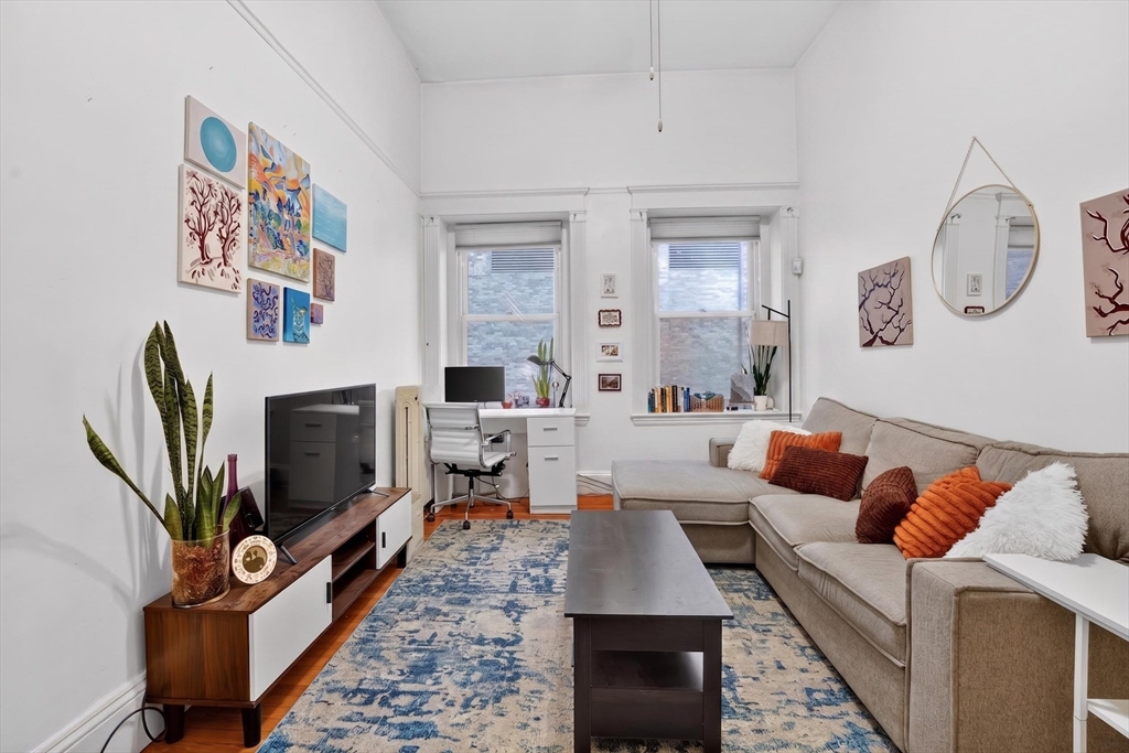 8 Garrison Street, Unit 111 Boston, MA 02116 - Photo 2 of 15 a living room with furniture a flat screen tv and a fireplace