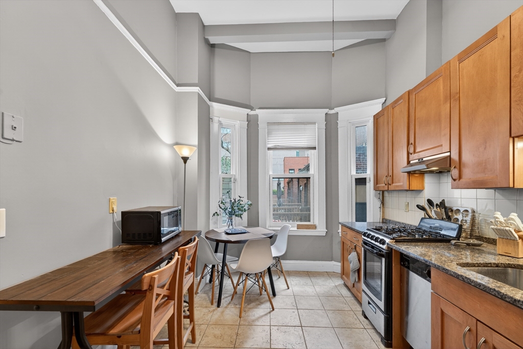 8 Garrison Street, Unit 111 Boston, MA 02116 - Photo 8 of 15 a kitchen with a table chairs sink and cabinets
