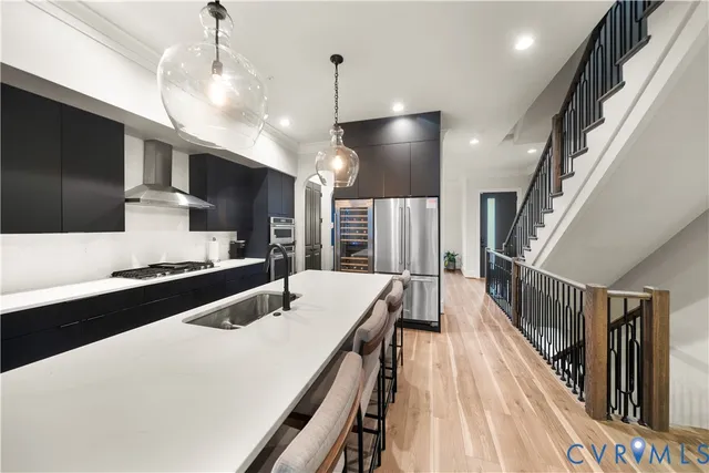 a kitchen with stainless steel appliances a kitchen island a stove a sink a refrigerator and a cabinets