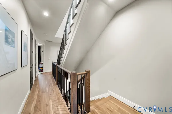 a view of a hallway with wooden floor and staircase