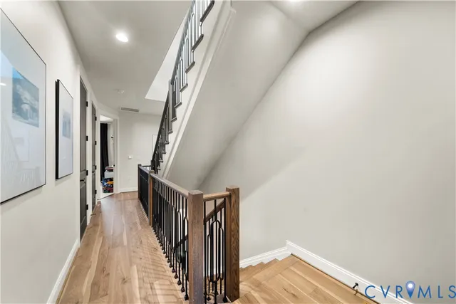a view of a hallway with wooden floor and staircase