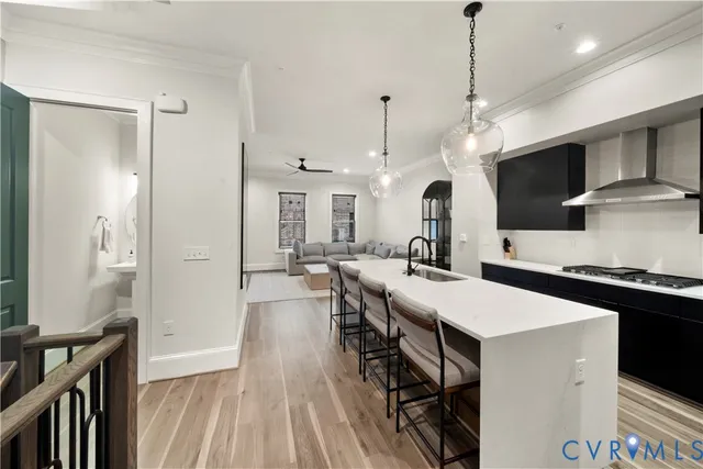 a large kitchen with stainless steel appliances a stove center island a refrigerator and a view of living room