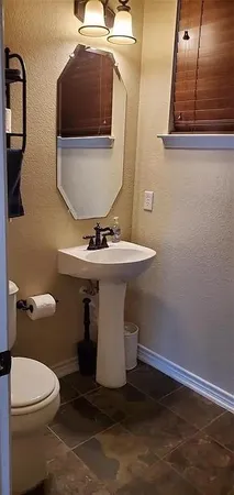 a bathroom with a sink a toilet and mirror