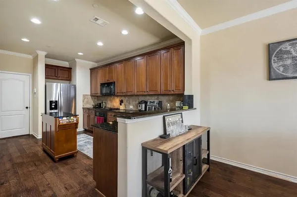 a kitchen with stainless steel appliances granite countertop a refrigerator a stove top oven a sink and dishwasher