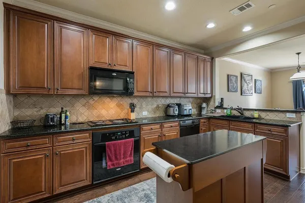 a kitchen with a stove sink microwave and cabinets