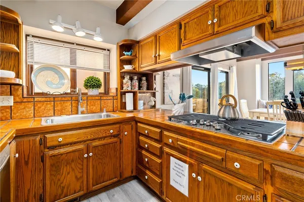 a kitchen with stainless steel appliances granite countertop a sink and wooden cabinets