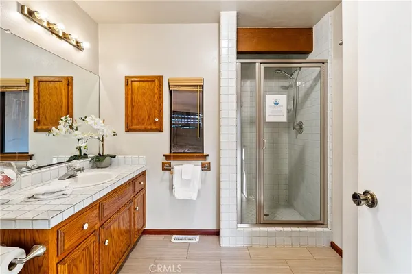 a bathroom with a double vanity sink mirror and shower