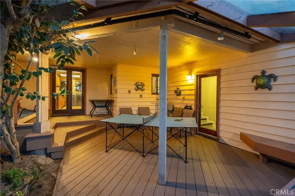 a view of a balcony with chairs and wooden floor
