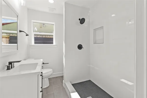a bathroom with a sink a toilet and shower