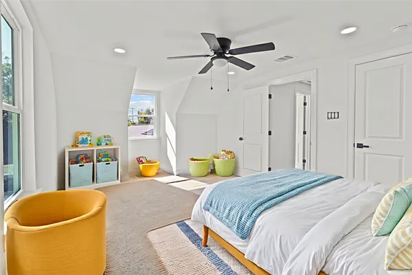 a bedroom with a bed a couch and a window