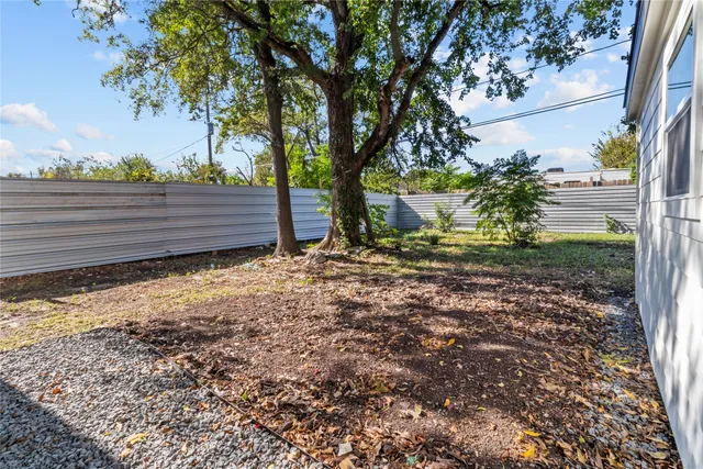 a view of a yard with wooden fence