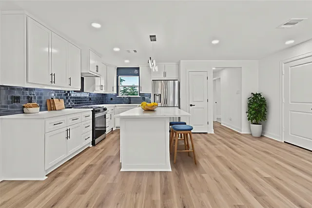 a kitchen with white cabinets and white appliances