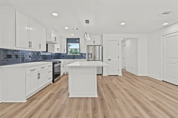 a kitchen with white cabinets sink and stainless steel appliances
