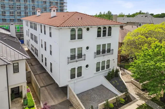 an aerial view of a house with balcony and trees al around
