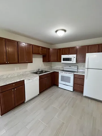 a kitchen with granite countertop stainless steel appliances and white cabinets