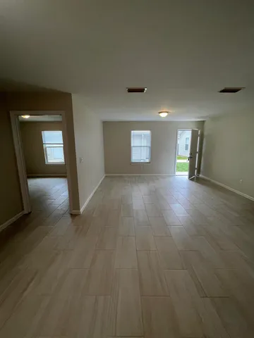 an empty room with wooden floor and mirror