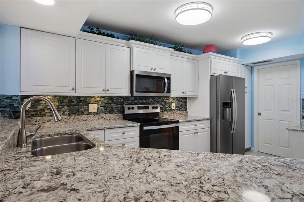 5151 Isla Key Boulevard South, Unit 421 St. Petersburg, FL 33715 - Photo 13 of 61 a kitchen with stainless steel appliances granite countertop a stove a sink and a refrigerator