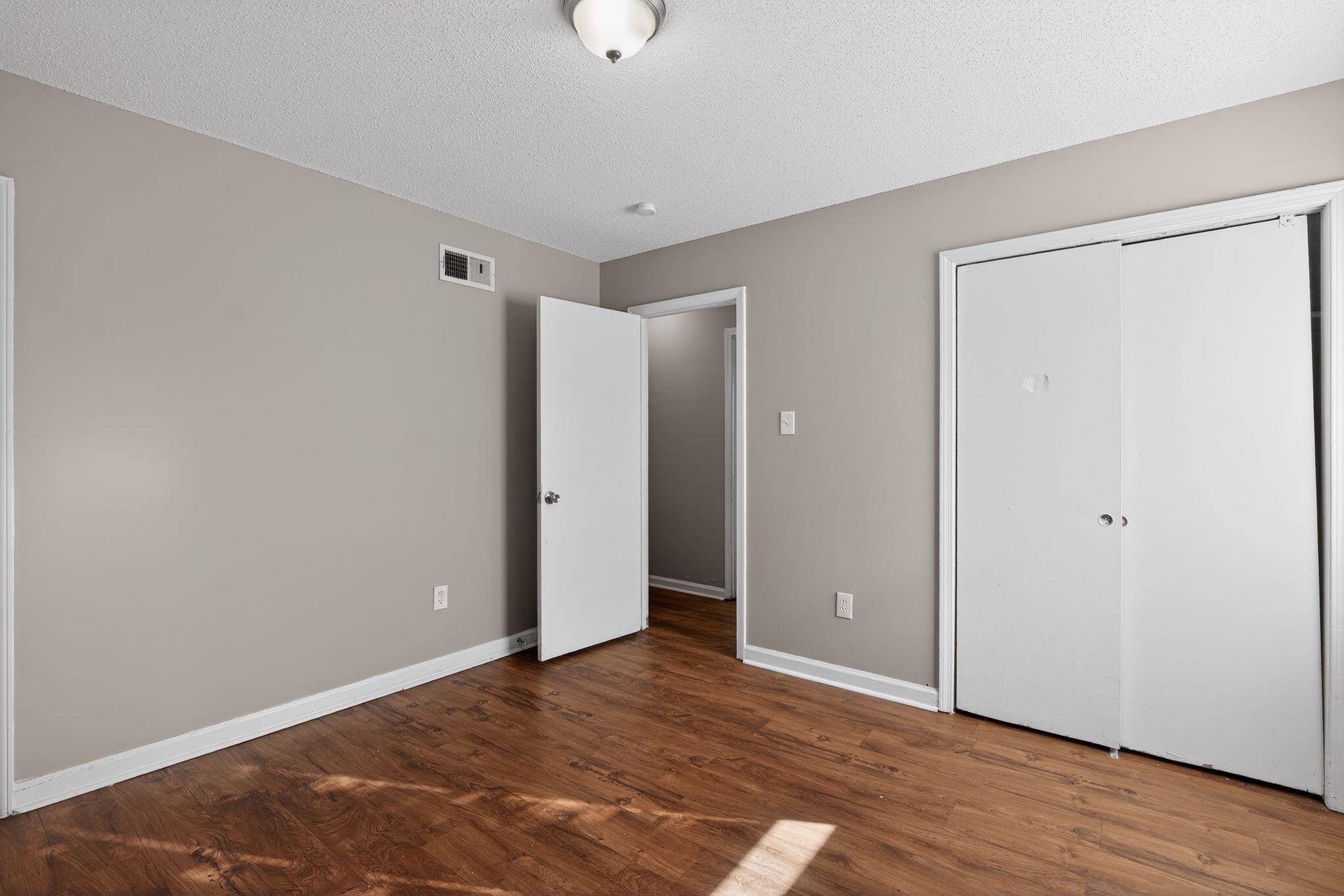 3637 Neely Road Memphis, TN 38109 - Photo 20 of 30 Unfurnished bedroom featuring a textured ceiling, a closet, and wood finished floors