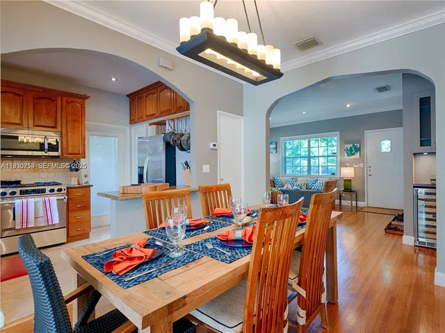 a living room with furniture kitchen view and a wooden floor