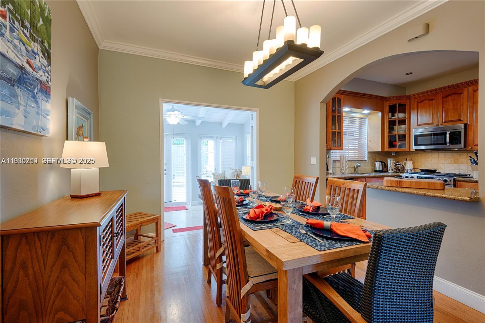 2308 Southwest 23rd Terrace Miami, FL 33145 - Photo 7 of 27 a view of a dining room with furniture a chandelier and wooden floor