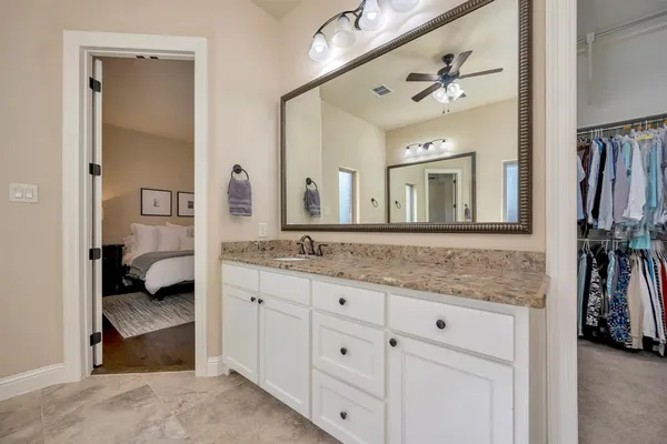 a spacious bathroom with a granite countertop double vanity sink a mirror a shower and a bathtub