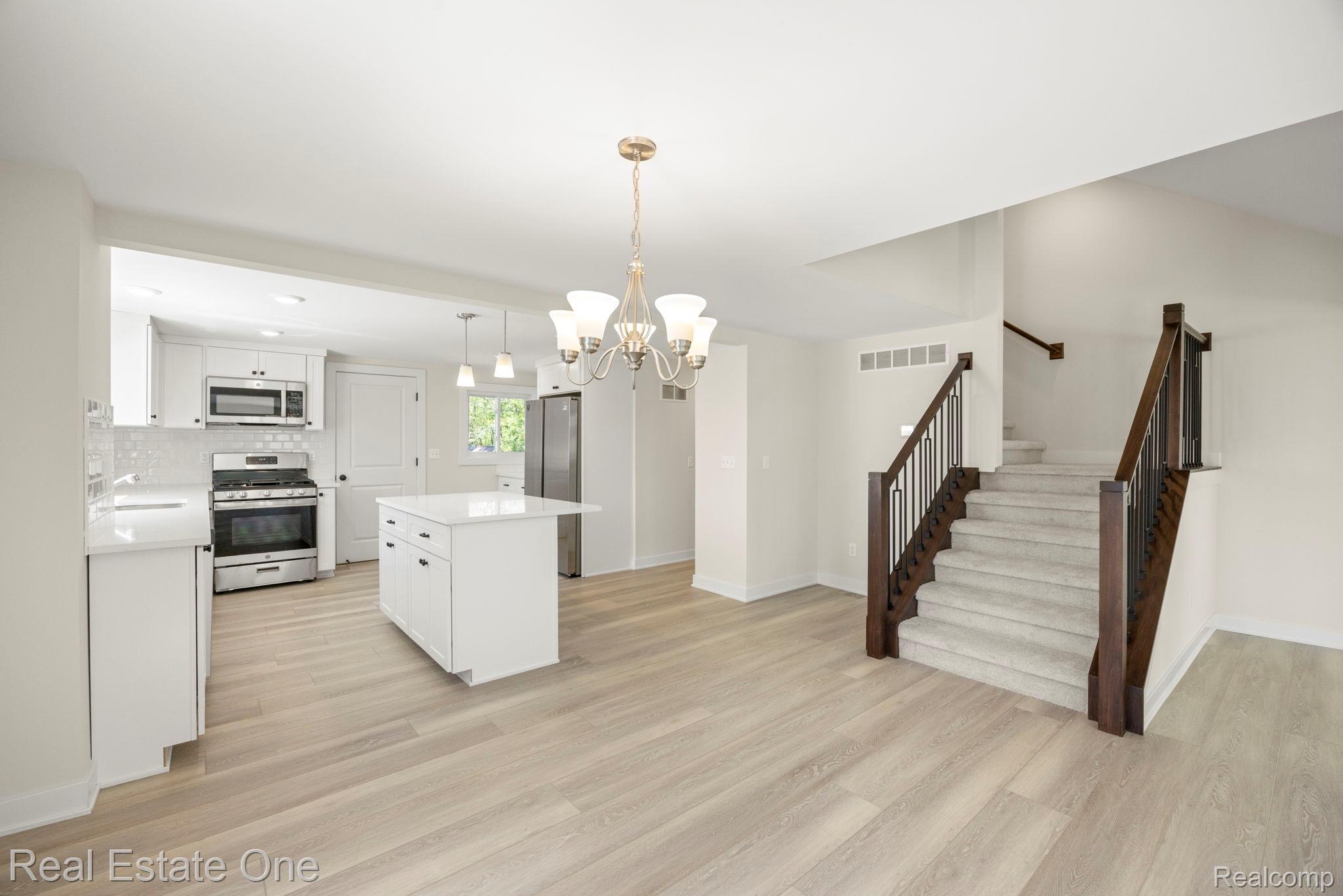 3200 Hessel Avenue Rochester, MI 48307 - Photo 15 of 32 Kitchen with a chandelier, stainless steel appliances, white cabinetry, and light wood-type flooring