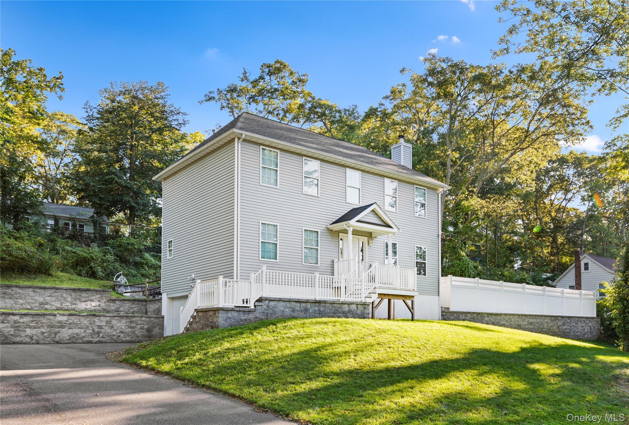 24 Belmont Road Sound Beach, NY 11789 - Photo 2 of 23 a front view of house with yard and trees in the background