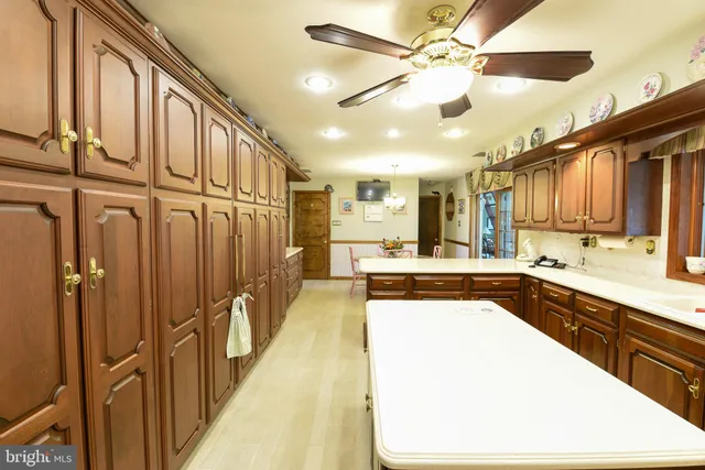 a living room with furniture a flat screen tv and kitchen view