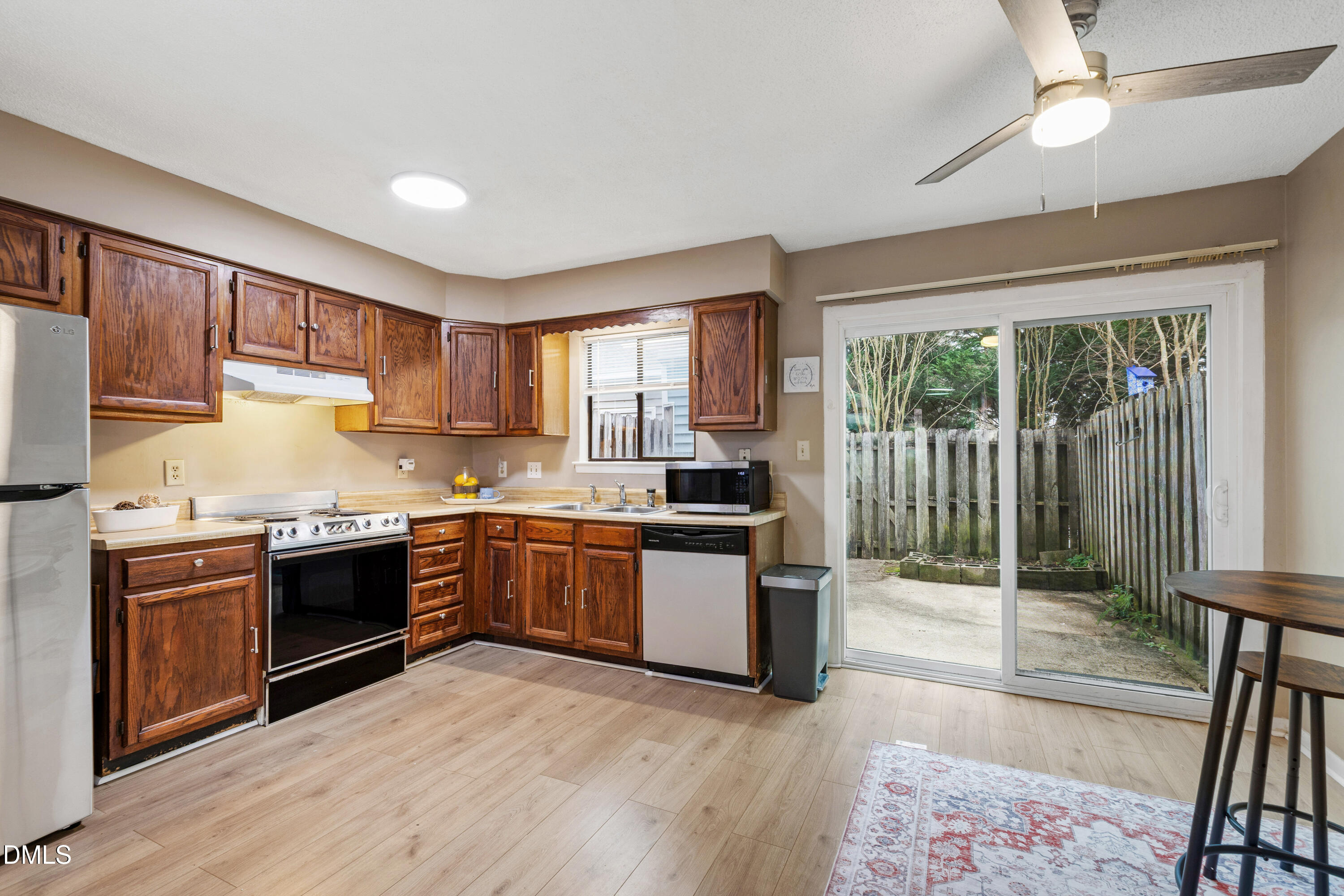 5810 Shady Grove Circle Raleigh, NC 27609 - Photo 15 of 21 a kitchen with stainless steel appliances granite countertop a stove a sink dishwasher a refrigerator and a microwave oven with wooden floor