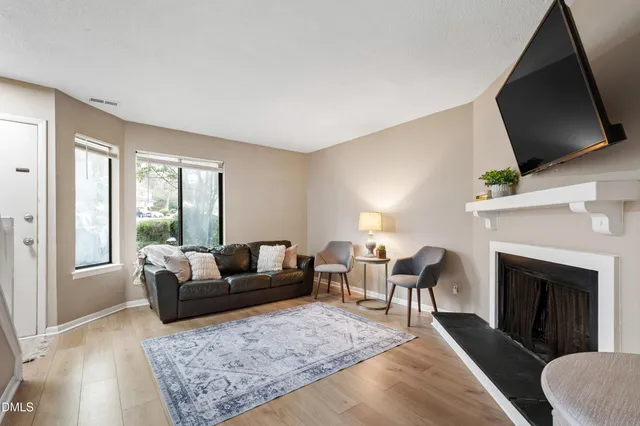 a living room with furniture a flat screen tv and a fireplace