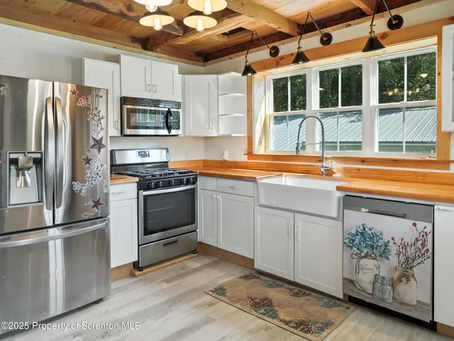 a kitchen with stainless steel appliances granite countertop a refrigerator a stove a sink and a microwave