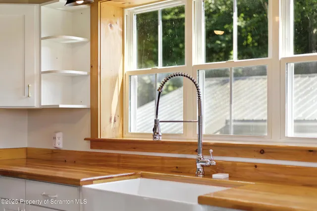 a view of a kitchen with a sink and large window